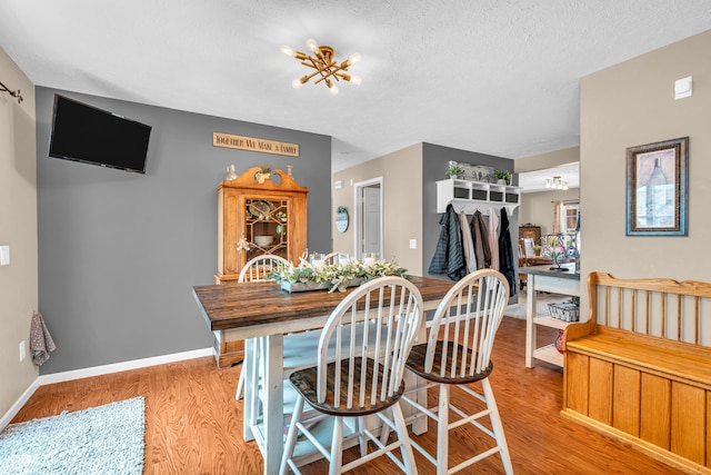 7047 Lancaster Ln, Avon, IN 46123 - dining room featuring light wood finished floors, a chandelier, and a textured ceiling