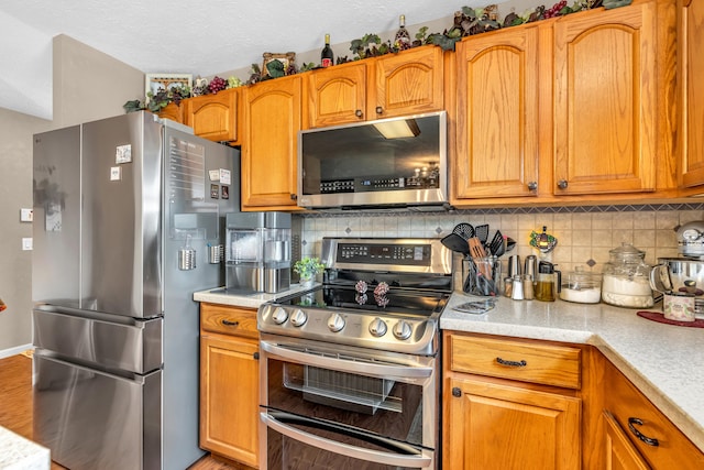 7047 Lancaster Ln, Avon, IN 46123 - kitchen with appliances with stainless steel finishes, backsplash, light countertops, and light wood-type flooring