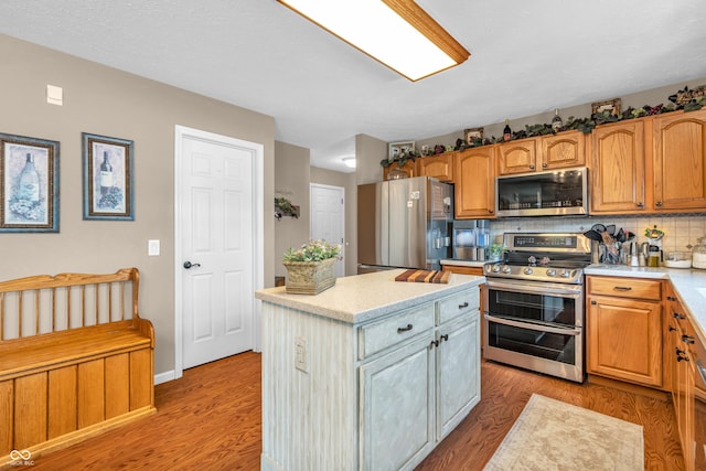 7047 Lancaster Ln, Avon, IN 46123 - kitchen featuring appliances with stainless steel finishes, a center island, light wood-style flooring, and tasteful backsplash