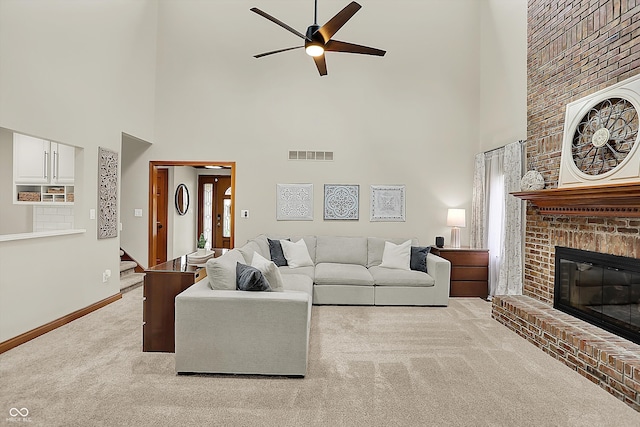 369 Rodeo Dr, Indianapolis, IN 46217 - living area with light carpet, a high ceiling, ceiling fan, a brick fireplace, and stairway