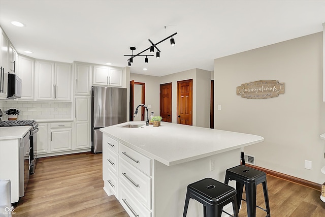 369 Rodeo Dr, Indianapolis, IN 46217 - kitchen with appliances with stainless steel finishes, light wood-type flooring, tasteful backsplash, light countertops, and recessed lighting