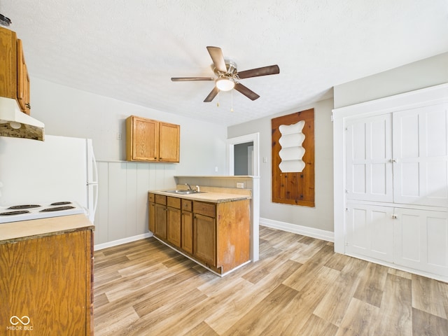 1201 Arrow Ave, Anderson, IN 46016 - kitchen featuring brown cabinetry, light wood finished floors, under cabinet range hood, a ceiling fan, and light countertops