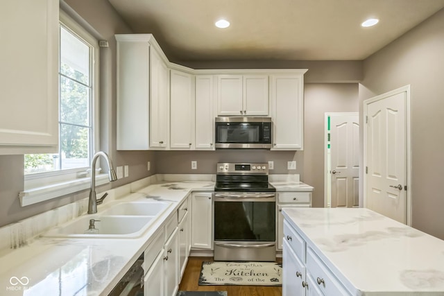 14156 Avalon E Dr, Fishers, IN 46037 - kitchen featuring appliances with stainless steel finishes, white cabinetry, recessed lighting, dark wood-style floors, and light stone countertops