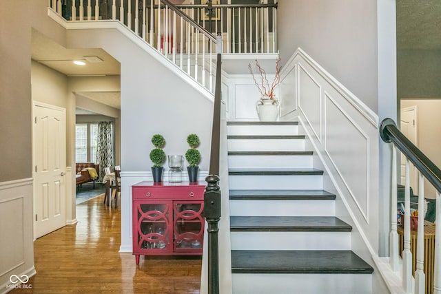 14156 Avalon E Dr, Fishers, IN 46037 - stairs featuring wood finished floors, a towering ceiling, and wainscoting