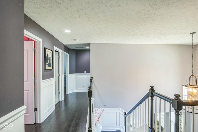 14156 Avalon E Dr, Fishers, IN 46037 - corridor featuring dark wood-style floors, a textured ceiling, wainscoting, a chandelier, and an upstairs landing