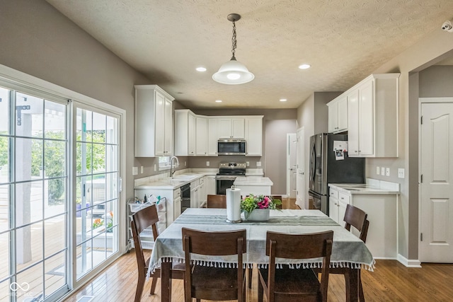14156 Avalon E Dr, Fishers, IN 46037 - kitchen with stainless steel appliances, light wood-type flooring, light countertops, a textured ceiling, and recessed lighting