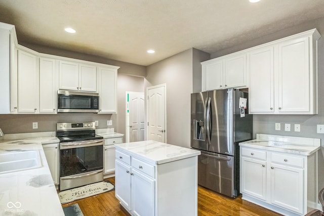 14156 Avalon E Dr, Fishers, IN 46037 - kitchen with appliances with stainless steel finishes, dark wood-style flooring, white cabinetry, recessed lighting, and a center island