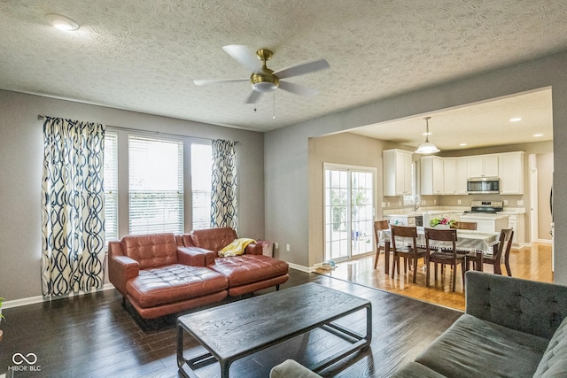 14156 Avalon E Dr, Fishers, IN 46037 - living area with plenty of natural light, a ceiling fan, wood finished floors, and a textured ceiling