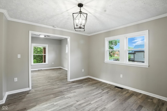 1430 W 14th St, Anderson, IN 46016 - empty room featuring wood finished floors, a chandelier, a textured ceiling, and crown molding