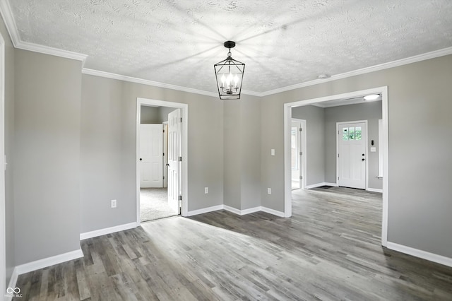 1430 W 14th St, Anderson, IN 46016 - unfurnished dining area featuring wood finished floors, a textured ceiling, a chandelier, and crown molding