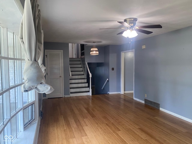 8008 Cherington Dr, Indianapolis, IN 46227 - unfurnished living room featuring wood finished floors, a ceiling fan, and stairs