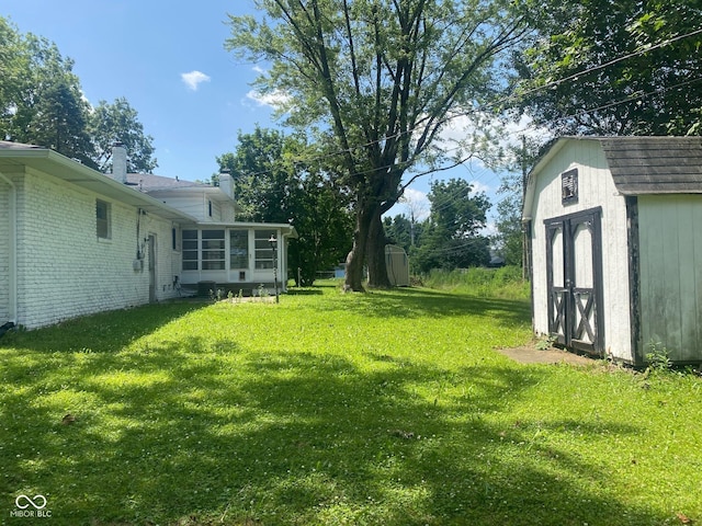 8008 Cherington Dr, Indianapolis, IN 46227 - view of grassy yard featuring a shed and a sunroom