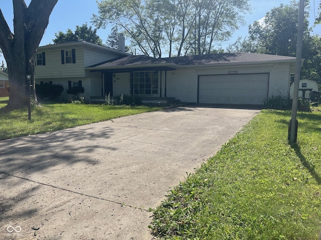 8008 Cherington Dr, Indianapolis, IN 46227 - split level home with brick siding, a garage, driveway, and a front yard
