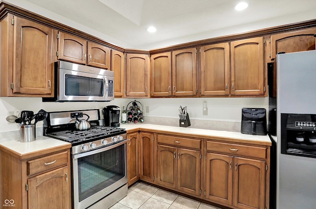 1456 Bent Tree Pl, Greenwood, IN 46143 - kitchen with stainless steel appliances, light countertops, light tile patterned floors, recessed lighting, and brown cabinets