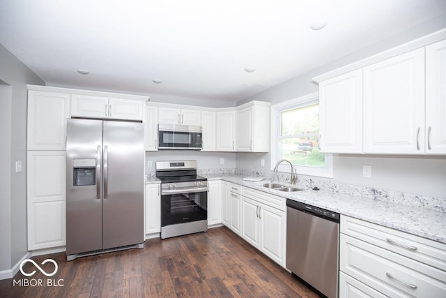 1855 E Deb Dr, North Vernon, IN 47265 - kitchen with appliances with stainless steel finishes, white cabinetry, light stone counters, dark wood finished floors, and recessed lighting
