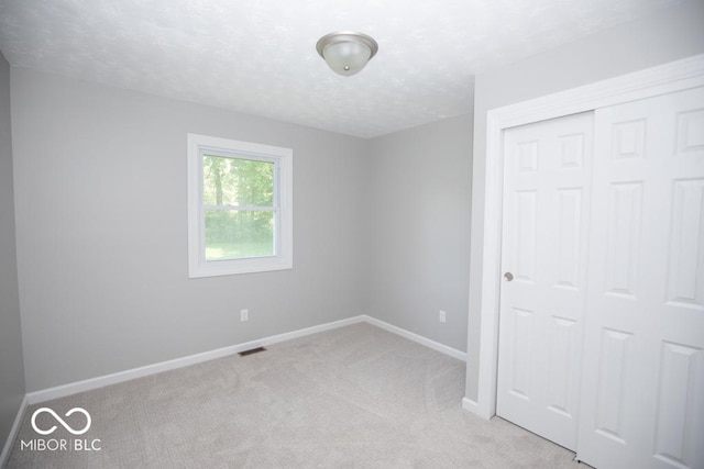 1855 E Deb Dr, North Vernon, IN 47265 - unfurnished bedroom featuring carpet, a closet, and a textured ceiling