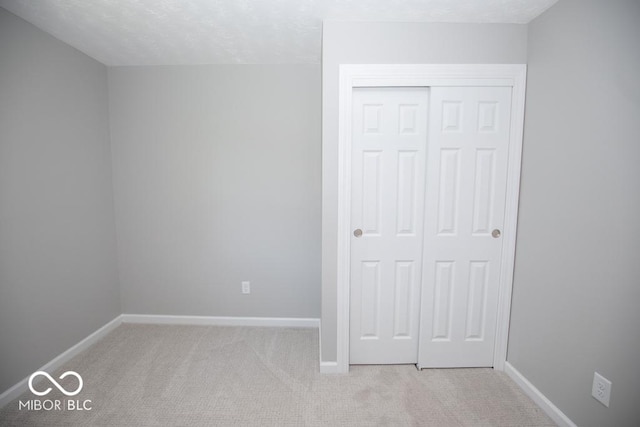 1855 E Deb Dr, North Vernon, IN 47265 - unfurnished bedroom featuring light carpet, a closet, and a textured ceiling