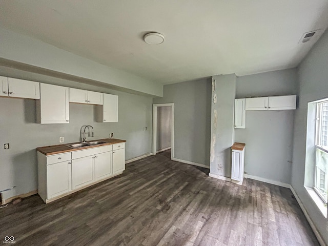 21 N Gladstone Ave, Indianapolis, IN 46201 - kitchen with dark wood finished floors, plenty of natural light, white cabinetry, and wooden counters