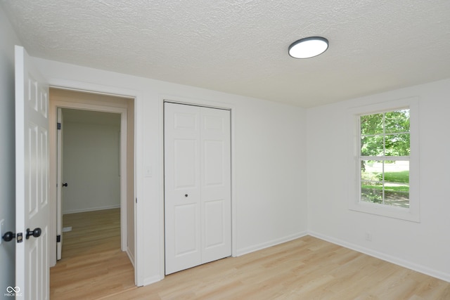 1740 Haynes Ave, Indianapolis, IN 46240 - unfurnished bedroom with light wood-type flooring, a textured ceiling, and a closet
