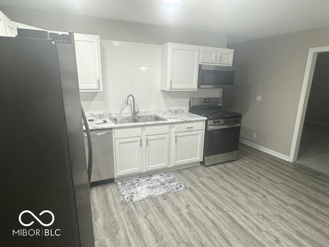 1306 Woodbine Dr, Anderson, IN 46011 - kitchen featuring appliances with stainless steel finishes, white cabinetry, and light wood finished floors