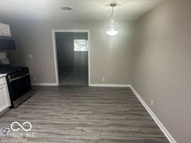 1306 Woodbine Dr, Anderson, IN 46011 - unfurnished dining area featuring baseboards and wood finished floors