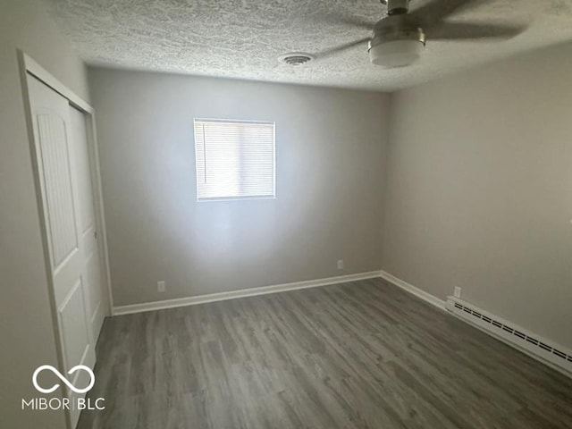 1306 Woodbine Dr, Anderson, IN 46011 - unfurnished bedroom featuring a baseboard radiator, wood finished floors, a closet, a textured ceiling, and ceiling fan