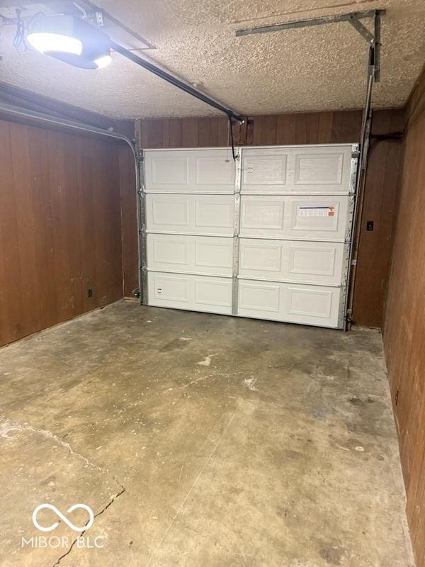1306 Woodbine Dr, Anderson, IN 46011 - garage with wooden walls and a garage door opener