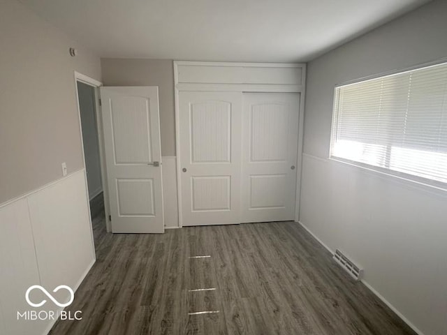 1306 Woodbine Dr, Anderson, IN 46011 - unfurnished bedroom with dark wood-type flooring and a closet