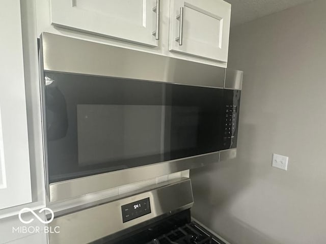 1306 Woodbine Dr, Anderson, IN 46011 - kitchen view of stainless steel microwave, white cabinets, and wall oven