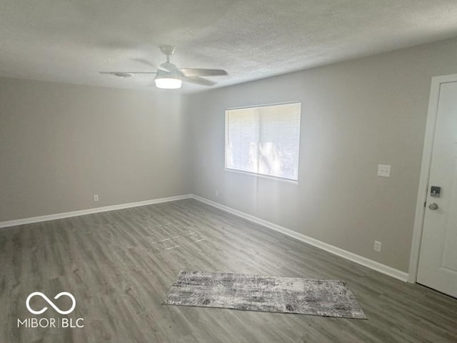1306 Woodbine Dr, Anderson, IN 46011 - spare room featuring wood finished floors, ceiling fan, and a textured ceiling