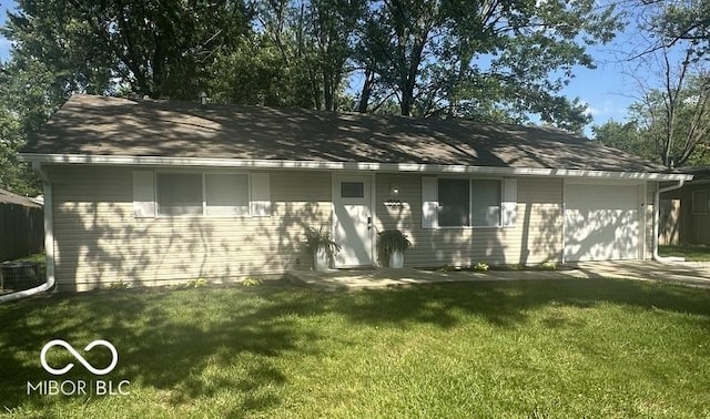1306 Woodbine Dr, Anderson, IN 46011 - back of property featuring an attached garage and a yard