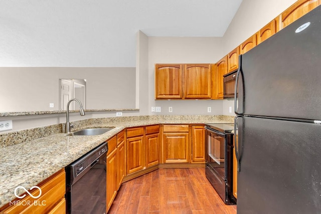 1139 Fernwood Way, Plainfield, IN 46168 - kitchen featuring black appliances, wood finished floors, light stone countertops, and brown cabinets