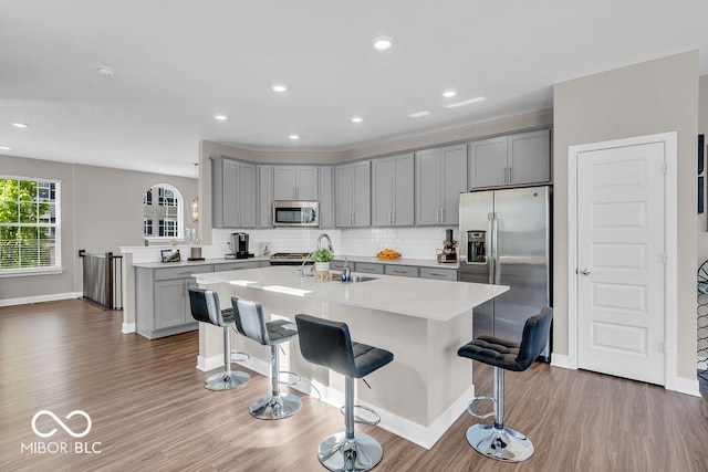 3546 Brampton Ln, Westfield, IN 46074 - kitchen with stainless steel appliances, gray cabinetry, light countertops, a breakfast bar, and recessed lighting