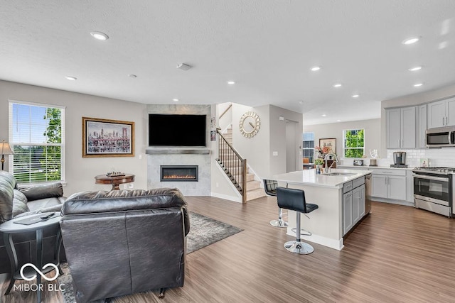 3546 Brampton Ln, Westfield, IN 46074 - living area with a tiled fireplace, recessed lighting, wood finished floors, and stairway