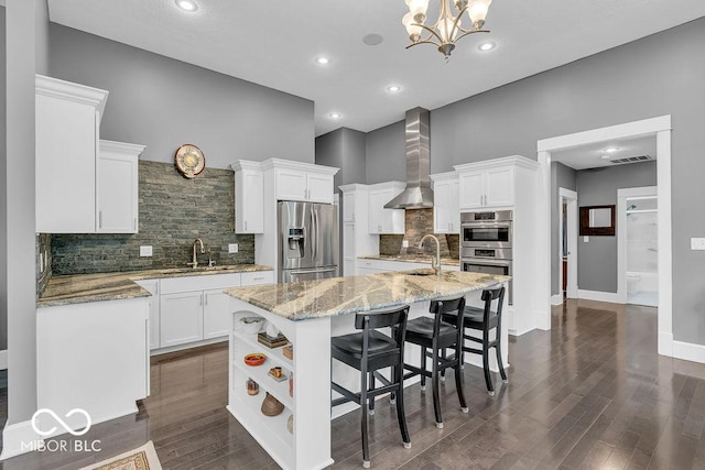 720 Willow Pointe N Dr, Plainfield, IN 46168 - kitchen with appliances with stainless steel finishes, wall chimney exhaust hood, white cabinets, a center island with sink, and backsplash