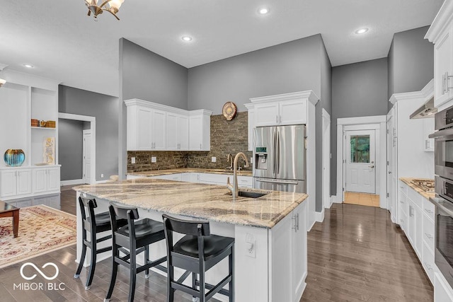 720 Willow Pointe N Dr, Plainfield, IN 46168 - kitchen with stainless steel refrigerator with ice dispenser, white cabinetry, an island with sink, light stone counters, and decorative backsplash