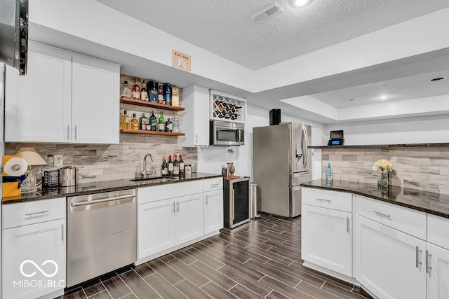 720 Willow Pointe N Dr, Plainfield, IN 46168 - kitchen featuring appliances with stainless steel finishes, open shelves, white cabinetry, dark stone countertops, and backsplash