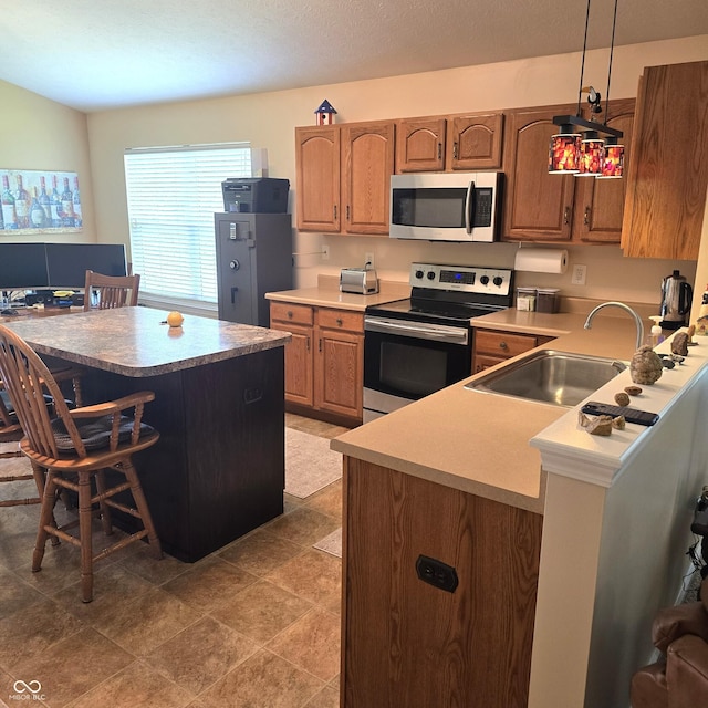 7608 Mather Ln, Indianapolis, IN 46239 - kitchen with stainless steel appliances, a breakfast bar area, hanging light fixtures, a desk, and light countertops