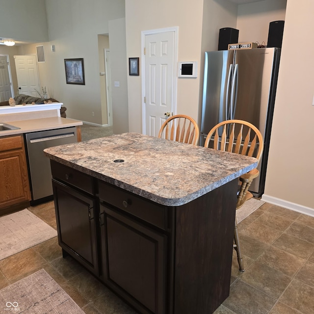 7608 Mather Ln, Indianapolis, IN 46239 - kitchen with stainless steel appliances, a kitchen breakfast bar, light countertops, and a kitchen island