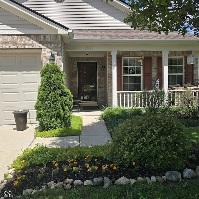 7608 Mather Ln, Indianapolis, IN 46239 - property entrance with a porch, brick siding, and an attached garage