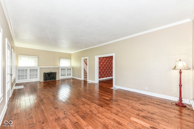 1325 Fordice Rd, Lebanon, IN 46052 - unfurnished living room with stairway, wood-type flooring, ornamental molding, a textured ceiling, and a brick fireplace