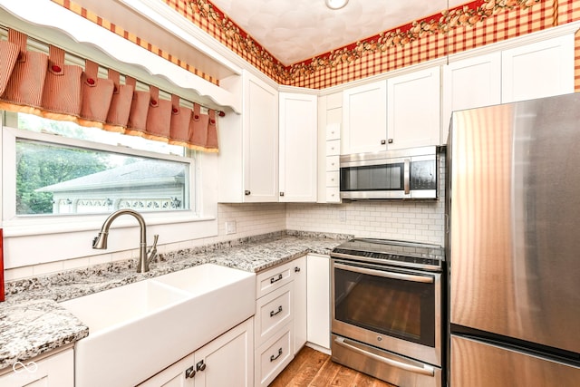 1325 Fordice Rd, Lebanon, IN 46052 - kitchen with appliances with stainless steel finishes, white cabinets, light wood-style flooring, and light stone countertops