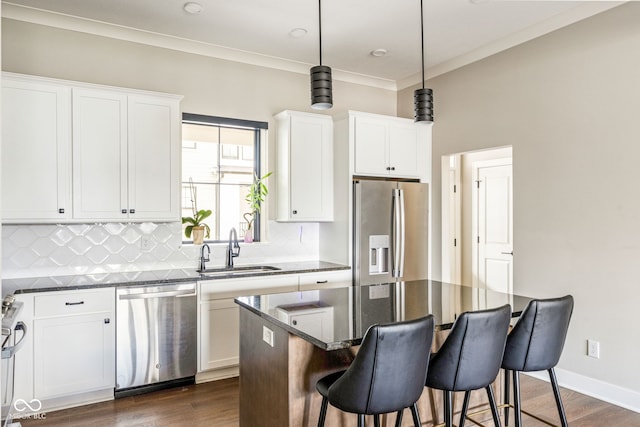 830 Freeland Way, Carmel, IN 46032 - kitchen with stainless steel appliances, tasteful backsplash, a breakfast bar area, dark wood finished floors, and a center island