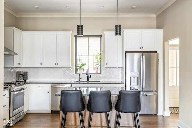 830 Freeland Way, Carmel, IN 46032 - kitchen with appliances with stainless steel finishes, dark wood finished floors, a breakfast bar, white cabinets, and crown molding