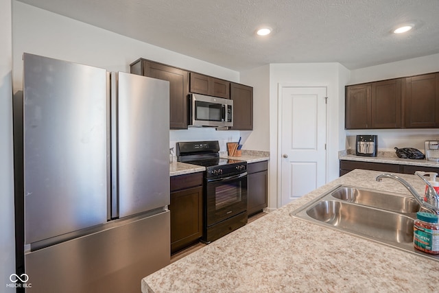 507 Redvine Dr, Sheridan, IN 46069 - kitchen with appliances with stainless steel finishes, dark brown cabinets, light countertops, recessed lighting, and a textured ceiling