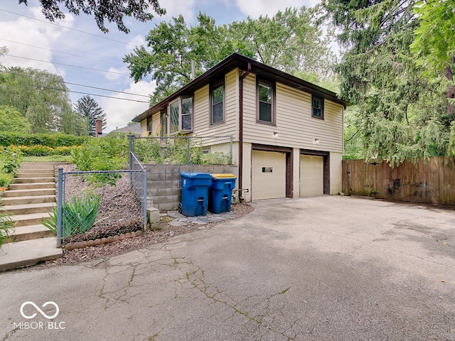 1908 W Northgate St, Indianapolis, IN 46228 - view of property exterior with asphalt driveway, a garage, and stairs