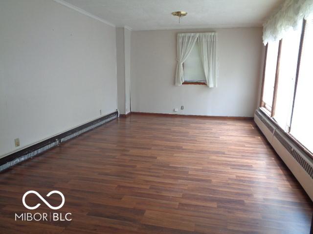 3253 W 34th St, Indianapolis, IN 46222 - unfurnished room featuring baseboard heating, a baseboard radiator, and wood finished floors