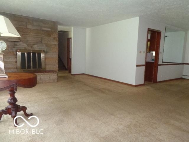 3253 W 34th St, Indianapolis, IN 46222 - unfurnished living room with carpet flooring, a textured ceiling, and a large fireplace