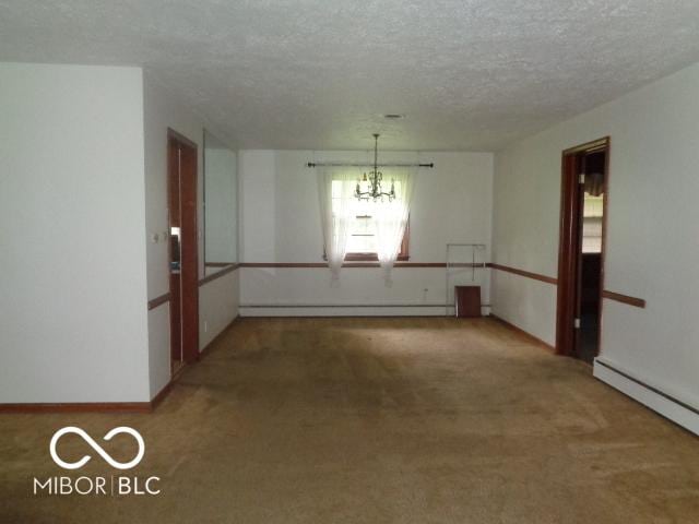 3253 W 34th St, Indianapolis, IN 46222 - carpeted spare room featuring a baseboard heating unit, a chandelier, a textured ceiling, and baseboard heating