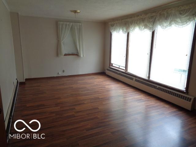 3253 W 34th St, Indianapolis, IN 46222 - spare room with a baseboard heating unit and wood finished floors